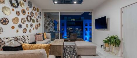 Un salon moderne avec un canapé, une table basse et un tapis à motifs.