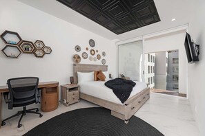 Ein modernes Schlafzimmer mit Bett, Schreibtisch und Stauraum.