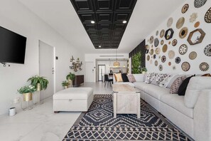 Ein modernes Wohnzimmer mit einer Couch, einem Couchtisch und einem gemusterten Teppich.