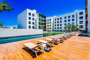 Een modern hotel met een zwembadgedeelte, uitgerust met ligbedden en een helder uitzicht op het zwembad.