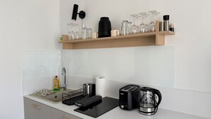 A kitchen with a wooden shelf holding glassware, a kettle, and a toaster. - Adorable 1-bedroom apartment in beautiful Gerlachov for your stay (Gerlachov)