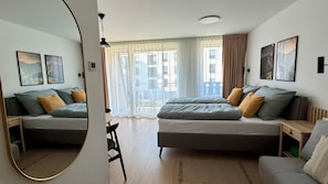 A modern hotel room with a large bed, a sofa, a dining table, and a balcony with a view. - Adorable 1-bedroom apartment in beautiful Gerlachov for your stay (Gerlachov)