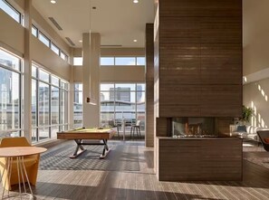 A modern indoor space with a pool table, seating area, and a fireplace. - Music City Paradise - 5 min Walk to Broadway (Nashville)