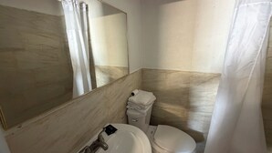 Un baño con un lavamanos blanco, un inodoro y un espejo grande.