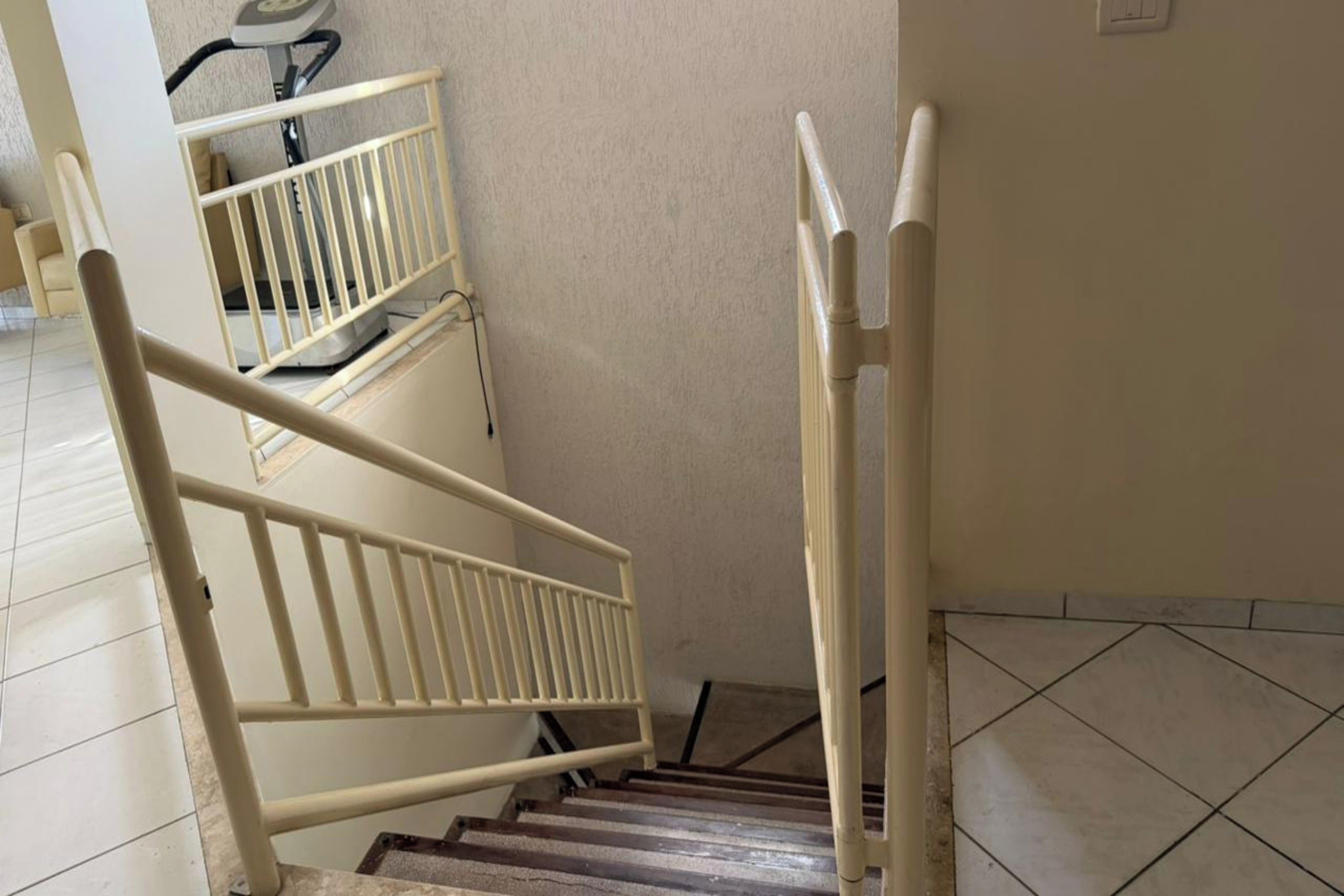 Una escalera con barandilla y pasamanos de metal.