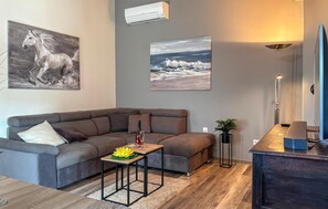 A modern living room with a sectional sofa, a small coffee table, and artwork on the walls. - Nice home in Porec with swimming pool (Porec)