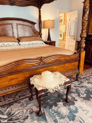 A bedroom with a four-poster bed, a bedside lamp, and a woven basket on a matching chair. - Orchid Studio close to Selby Botanical Gardens, central air conditioning/heat (Sarasota)