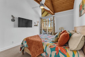 A bedroom with a bed, a ceiling fan, a TV, and a window with curtains. - Indian Wells Condo, Steps to Pool,  Minutes to La Quinta El Paseo and Coachella (Indian Wells)