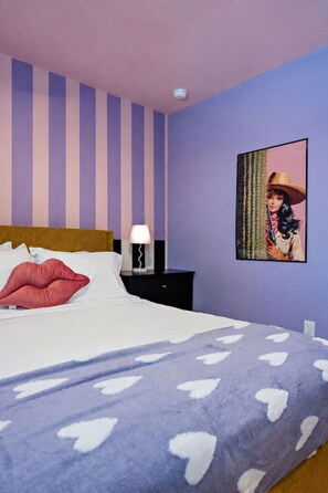 A bedroom with a bed, a nightstand, a lamp, and a wall-mounted picture. - Modern 1BR + Sofa Bed | Sleeps 4 (Houston)