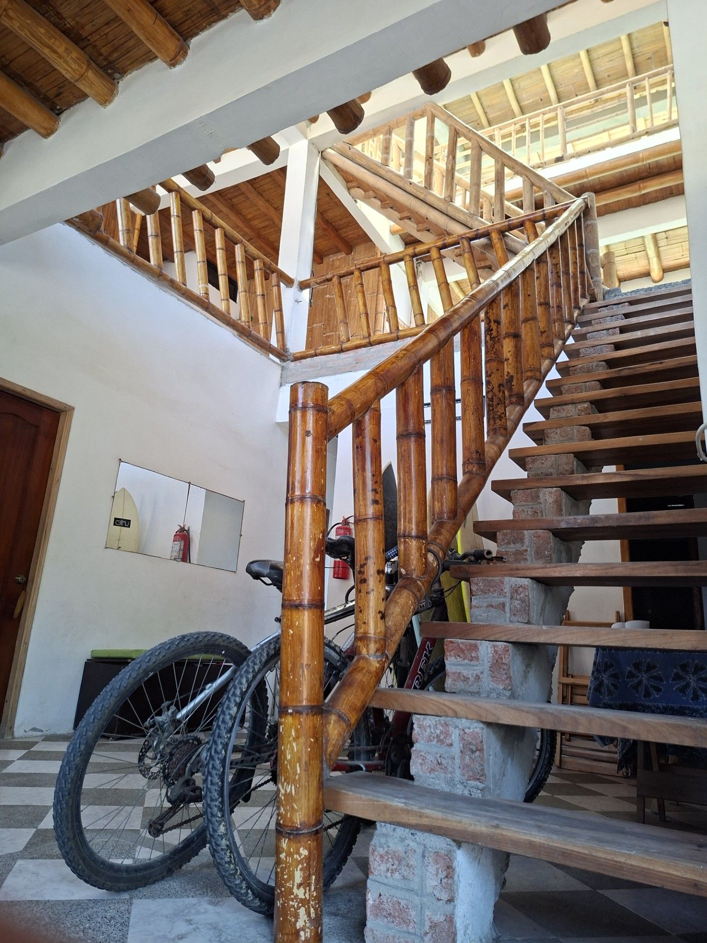 A wooden staircase with a bamboo railing leading to an upper level.