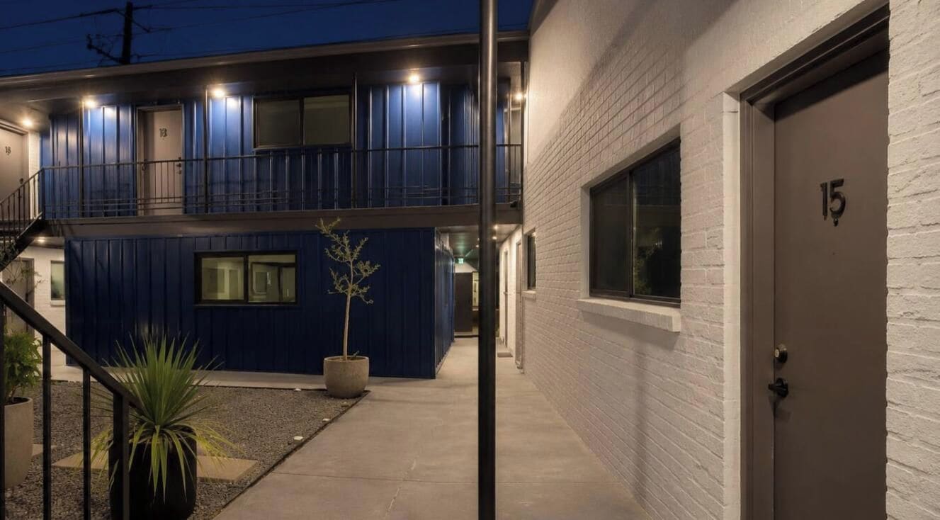 A two-story building with a blue exterior and a white door marked with the number 15.