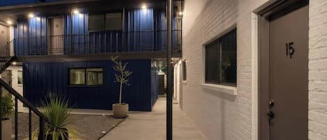 Un edificio de dos pisos con fachada azul y una puerta blanca marcada con el número 15.