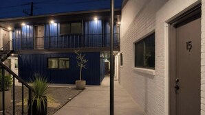 A two-story building with a blue exterior and a white door marked with the number 15. - Designer 1BR | Sleeps 4 | Near DT (Houston)