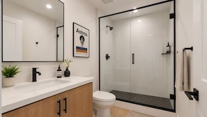 Une salle de bain moderne équipée d’une douche, de toilettes et d’un lavabo.
