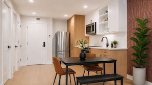 Une cuisine moderne avec une table et des chaises, un réfrigérateur et un four à micro-ondes.