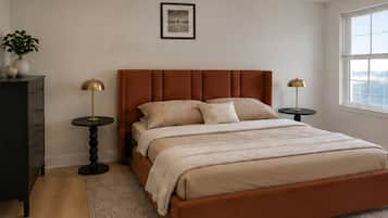 A bedroom with a bed, bedside tables, a dresser, a window, and a framed picture on the wall.
