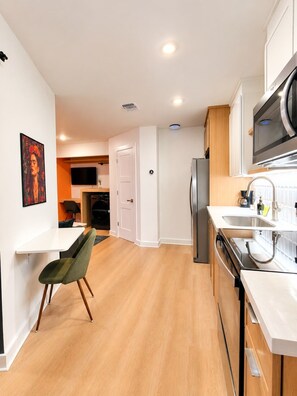A modern kitchen with a built-in oven, microwave, and stainless steel sink. - Modern 1BR | Free Parking | Sleeps 4 (Houston)