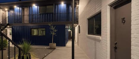 Un edificio moderno con fachada azul, una escalera de hormigón y una puerta con el número 15.