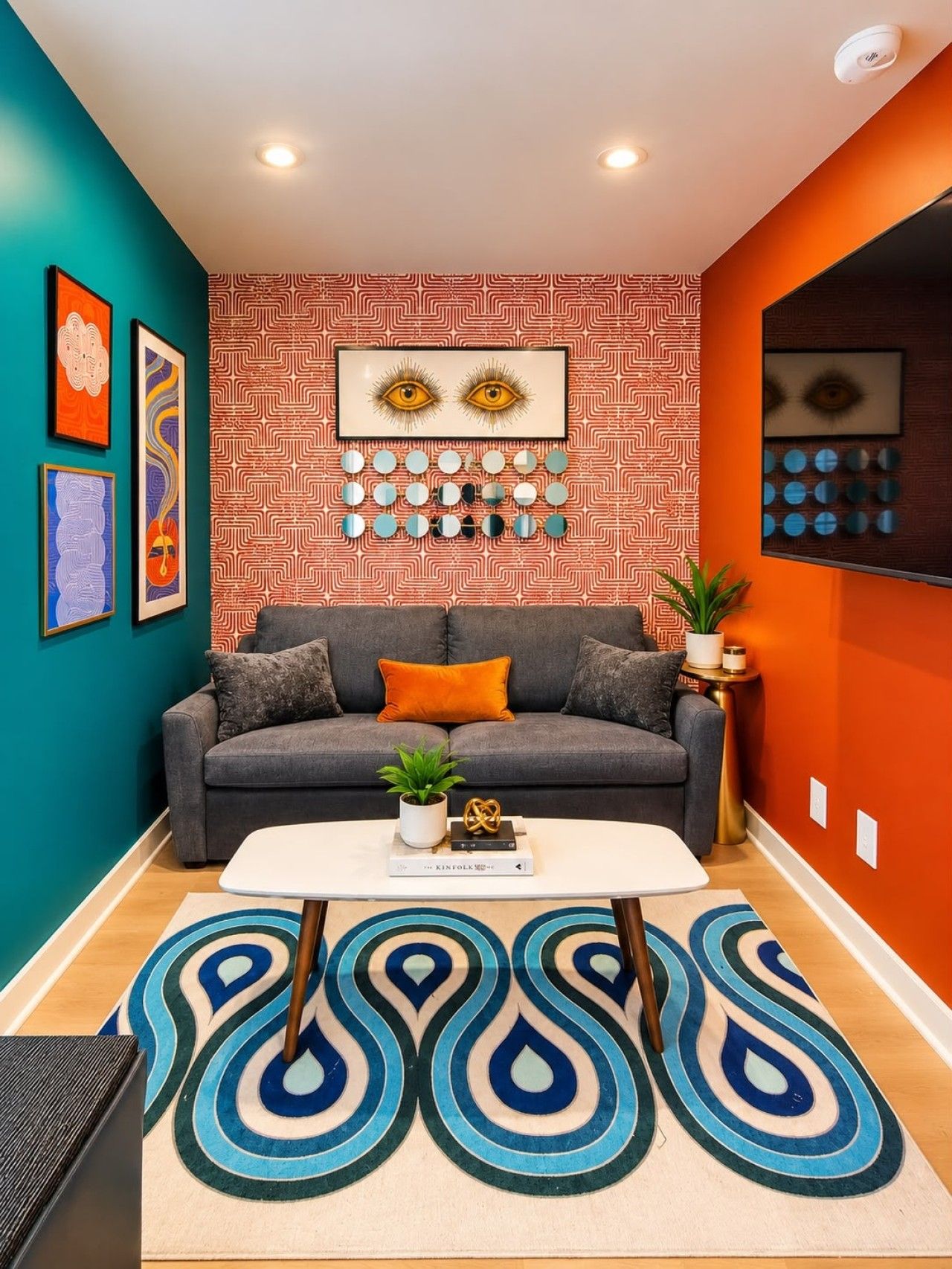 A modern living room with a grey sofa, orange cushions, a white coffee table, and a patterned rug.