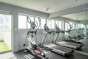 A gym with treadmills, elliptical machines, and a mirrored wall. - La Buenavista Prado Residences (La Victoria)