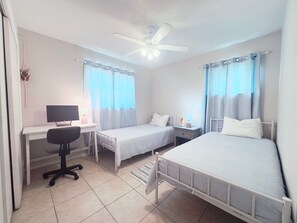 A bedroom with two beds, a desk, a chair, and a ceiling fan. - Conveniently located between Siesta key beach and downtown Sarasota.2/1 unit. (Sarasota)