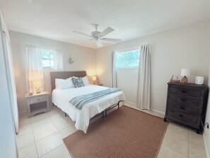 A bedroom with a bed, nightstands, a dresser, a ceiling fan, and windows. - Conveniently located between Siesta key beach and downtown Sarasota.2/1 unit. (Sarasota)