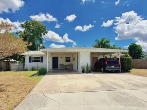 A single-story house with a covered garage, a front porch, and a driveway. - Conveniently located between Siesta key beach and downtown Sarasota.2/1 unit. (Sarasota)