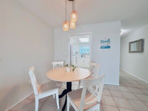A dining area with a round table, four chairs, and pendant lighting. - Conveniently located between Siesta key beach and downtown Sarasota.2/1 unit. (Sarasota)