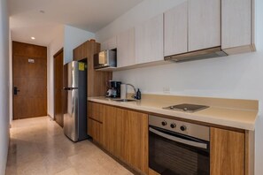 Een moderne keuken met houten kastjes, roestvrijstalen apparatuur en een inbouwoven.