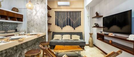 Una cocina moderna con comedor, sofá y televisor.