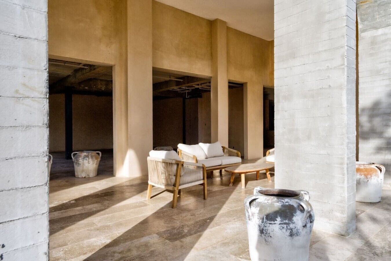 A spacious interior with a high ceiling, exposed beams, and a seating area with a table and chairs.