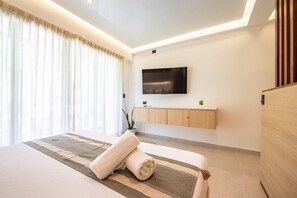 A modern hotel room with a large bed, a mounted TV, and a wooden cabinet. - Stylish 1BR | Gym, Rooftop Pool & Lounge w/Parking (Playa del Carmen)