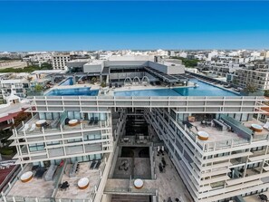 A multi-story hotel with a rooftop pool and outdoor seating areas. - Luxury Beach Condo w/Rooftop Pool, Gym & Parking (Playa del Carmen)