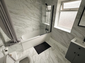 A modern bathroom with a glass-enclosed shower, a white bathtub, and a vanity with a mirror. - 3 Bedroom 2 Bathroom flat. 15mins walk to Wembley Stadium. Secure gated parking. (Wembley)