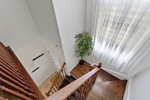 A wooden staircase with a potted plant beside it. - Stylish 2-bedroom, 3-bath townhouse about 15 minutes from Niagara Falls. (St. Catharines)