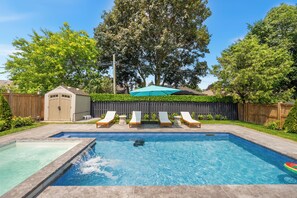 A backyard with a swimming pool, a wooden deck, and a fenced area. - Luxury Spa Escape with Pool & Jacuzzi [Near Rogers Stadium] (Toronto)
