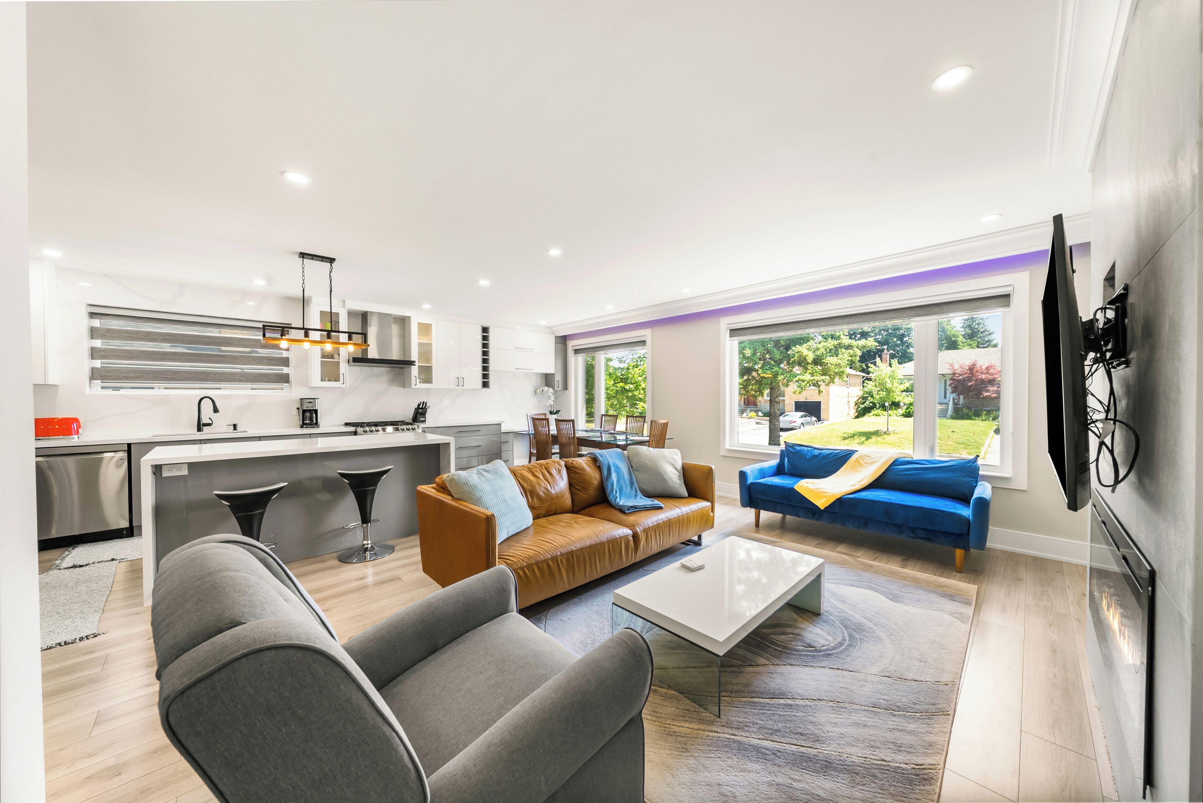 A modern living room with a sofa, coffee table, and a TV mounted on the wall.