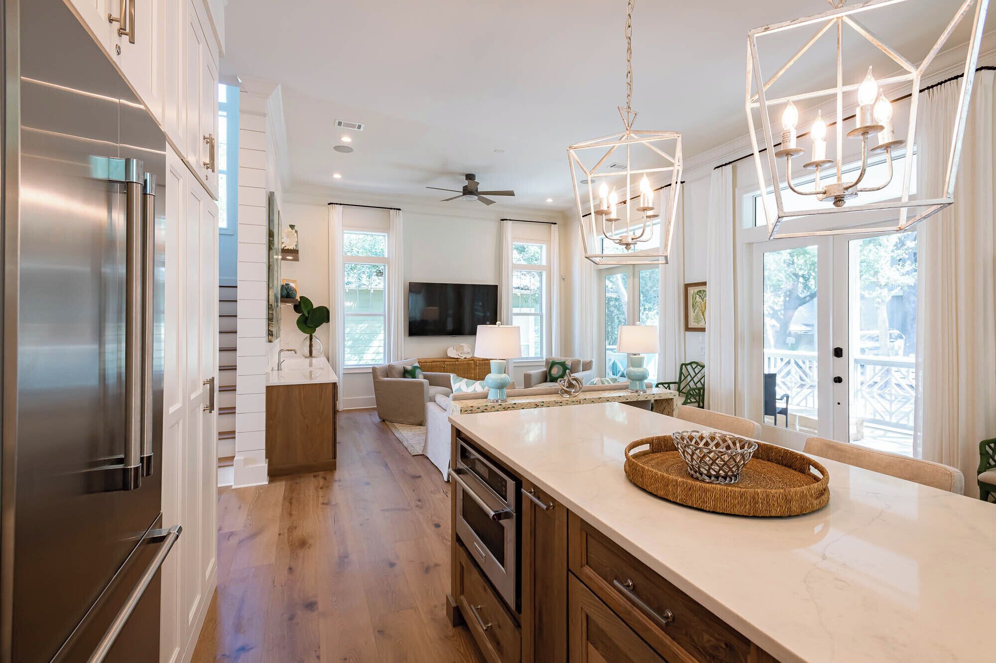 A modern kitchen with a large island, stainless steel appliances, and a dining area with a view.