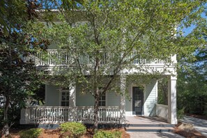 A two-story house with a porch, a small garden, and a sign welcoming visitors to Bilken. - Private Pool, Steps From Seaside- Billiken Bungalow by Royal Destinations (Santa Rosa Beach)