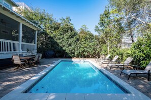 A rectangular swimming pool with a tiled edge, surrounded by a patio area with chairs and a table. - Private Pool, Steps From Seaside- Billiken Bungalow by Royal Destinations (Santa Rosa Beach)