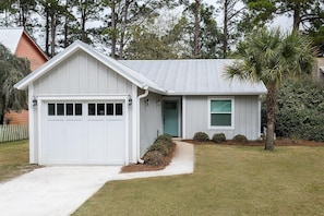 A single-story house with a garage, a front door, and a small porch area.
