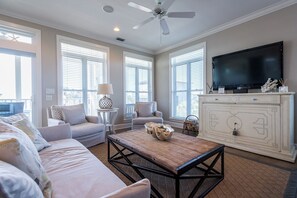 A living room with a sofa, armchairs, a coffee table, a TV, and a ceiling fan. - Private Pool, Gulf Views, Near Seaside- Elizabeth White House (Santa Rosa Beach)