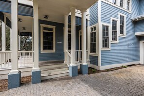 A two-story building with a porch, white columns, and a blue exterior. - WaterColor Lake Views & Resort Amenities- Far Niente by Royal Destinations (Santa Rosa Beach)