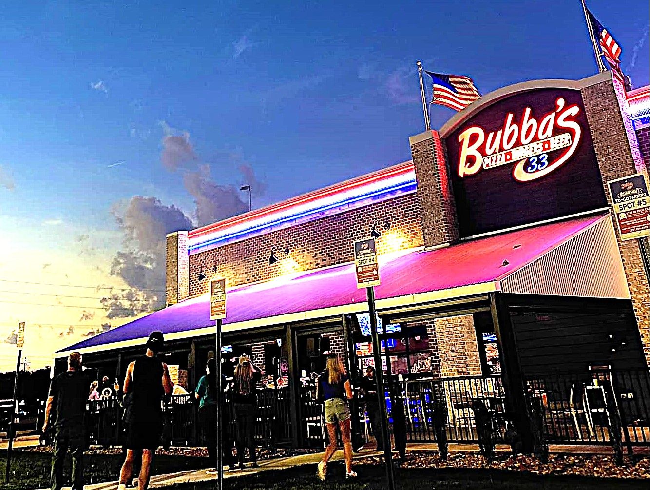 En restaurang som heter Bubba's, med en stor skylt, uteservering och ett överbyggt område.