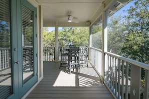 A covered porch with a table and chairs, a ceiling fan, and a view of trees. - 2 Community Pools, Walk to Beach- Follow the Heron by Royal Destinations (Santa Rosa Beach)
