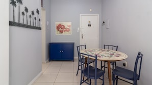 A dining area with a round table, chairs, a blue cabinet, and a door with a sign. - 7 Mins From Copacabana Beach Pfa603 (Rio de Janeiro)