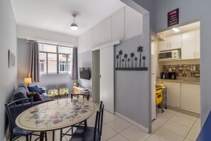 A compact living space with a dining area, kitchenette, and a TV mounted on the wall. - 7 Mins From Copacabana Beach Pfa603 (Rio de Janeiro)