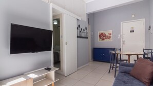 A modern living room with a flat-screen TV, a sofa, a coffee table, and a dining area with chairs. - 7 Mins From Copacabana Beach Pfa603 (Rio de Janeiro)