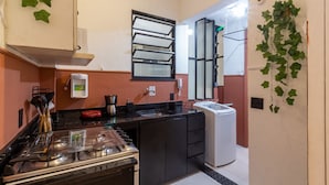 A compact kitchen with a gas stove, a coffee maker, and a small refrigerator. - 2BR Apt Just 7 Mins to Copacabana Beach Br502 (Rio de Janeiro)