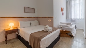A hotel room with a bed, bedside table, lamp, and a window with curtains. - 2BR Apt Just 7 Mins to Copacabana Beach Br502 (Rio de Janeiro)